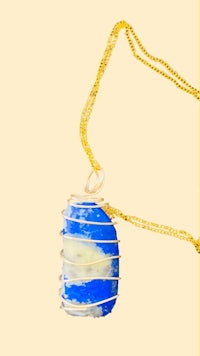 a blue glass pendant on a gold chain