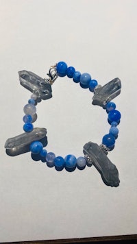 a bracelet with blue glass beads on a table