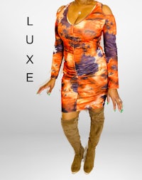 a woman wearing a tie dye dress and thigh high boots