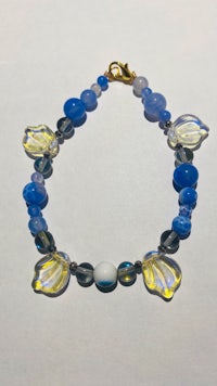 a bracelet with blue and yellow beads on a white surface