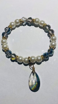 a bracelet with a pearl and crystal charm